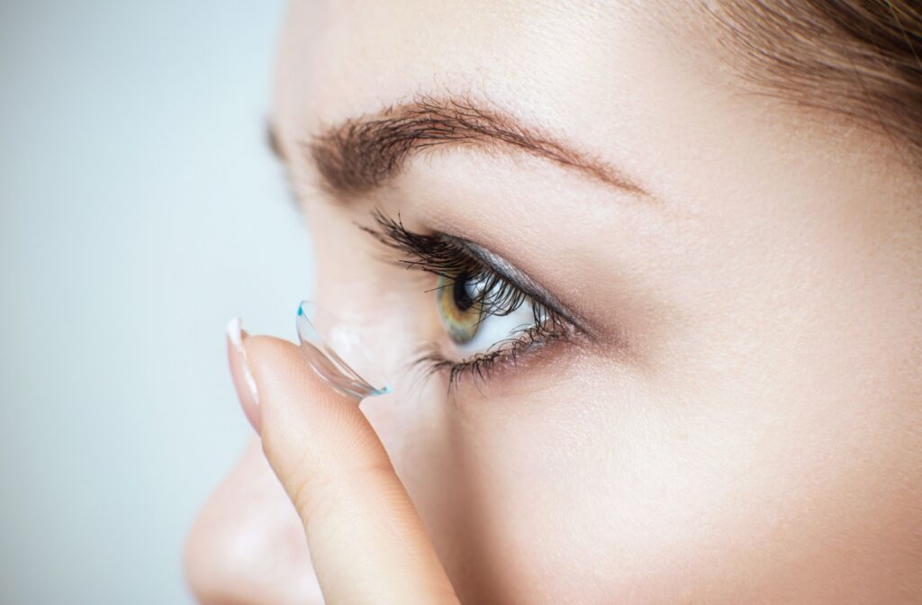 Close-up of a person with a soft contact lens on their finger about to put it in their eye.