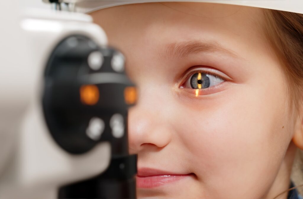 Close-up of a young patient receiving a comprehensive eye exam, with a yellow light over their eye