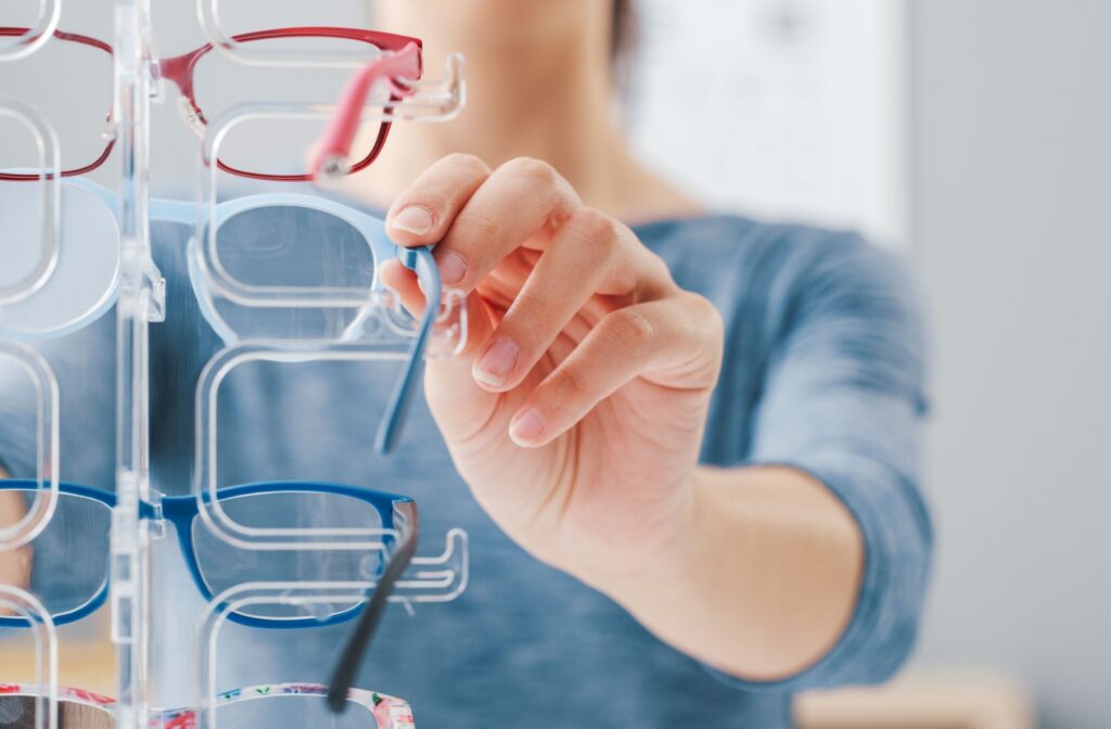 A woman browses various eyeglasses for the right fit.