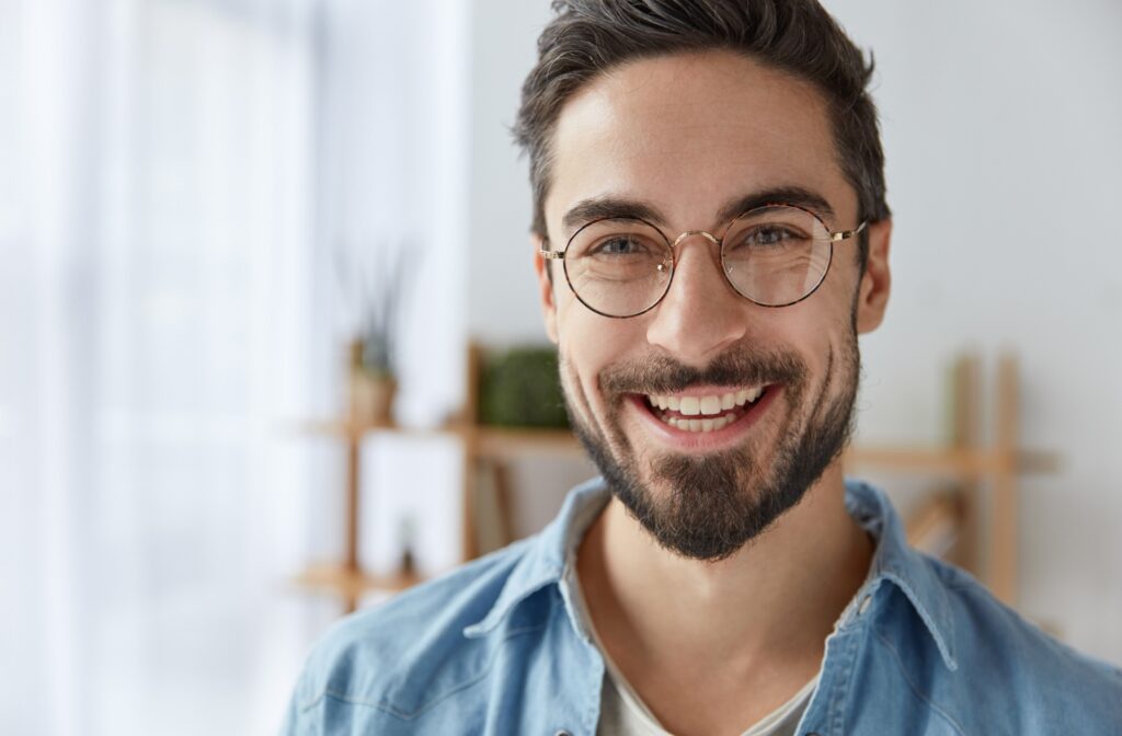 A man smiles at the camera while wearing handpicked eyewear.