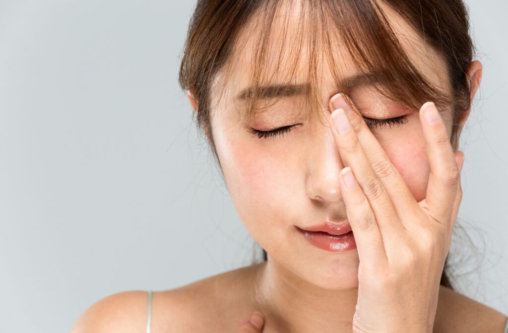 A woman rubs her eyes, feeling the strain of eye fatigue.